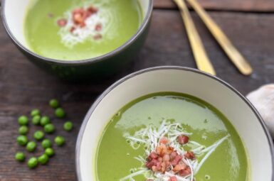 Creamy green peas soup with ground cheese on the top