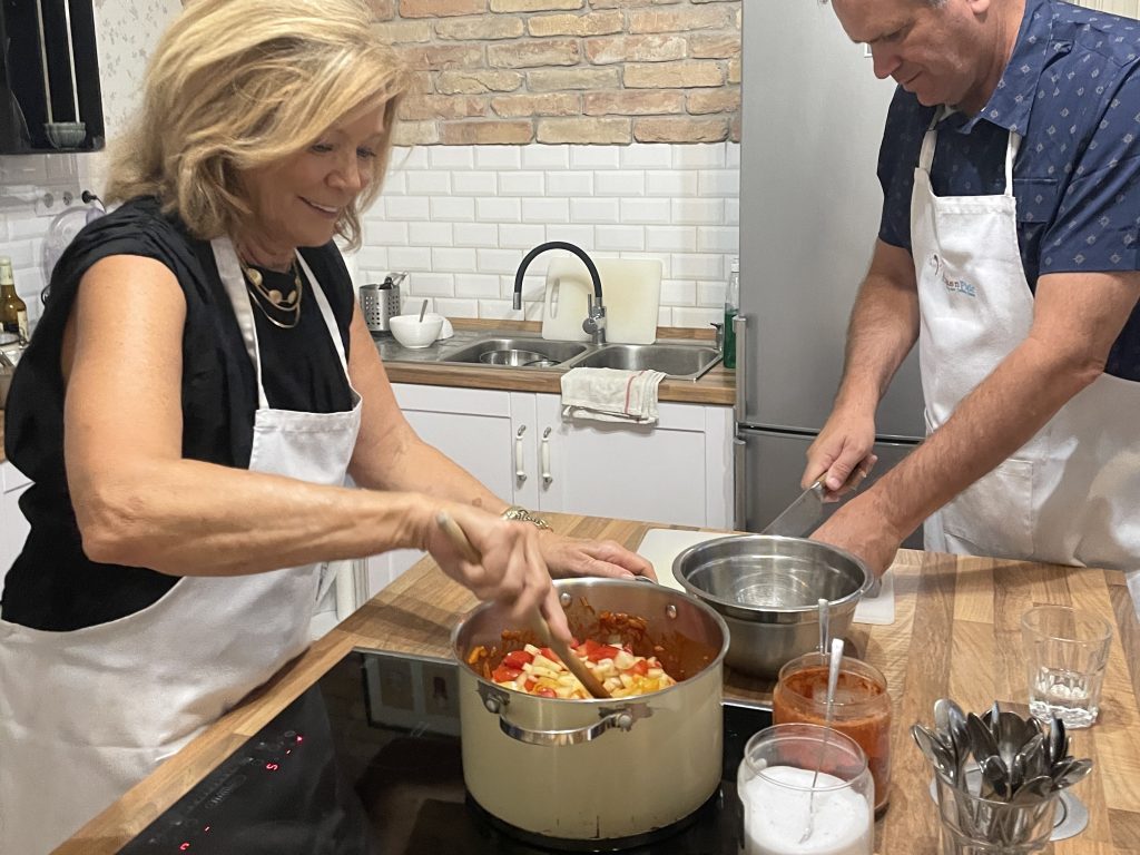 Guests making Chicken Paprikas during a Hungarian cooking class at Flavors of Budapest