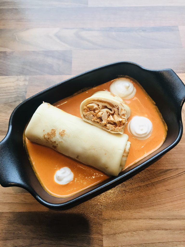 Traditional Hungarian Hortobagyi pancake filled with savory meat and paprika sauce.