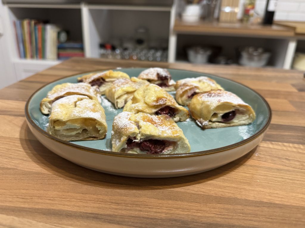 Freshly baked stretched Hungarian strudels filled with apple and sweet cottage cheese cream with sour cherry on a serving tray at Flavors of Budapest