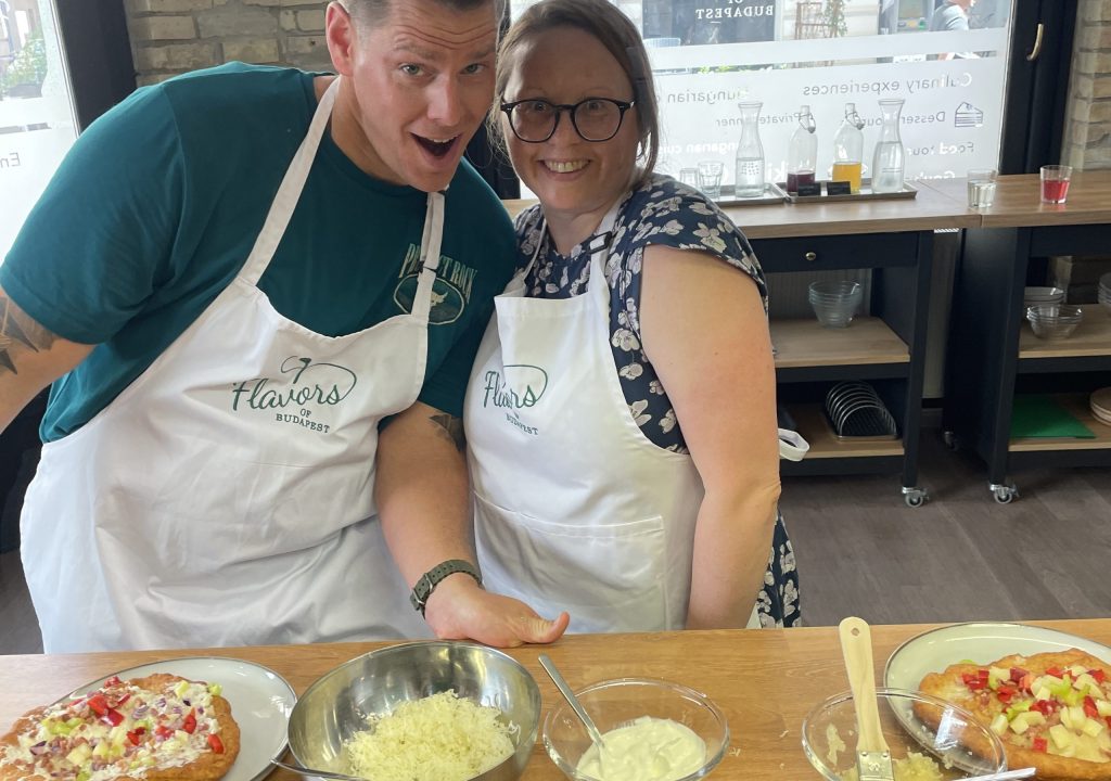 Guests with freshly made Hungarian langos topped with garlic, sour cream, cheese, and other traditional toppings.