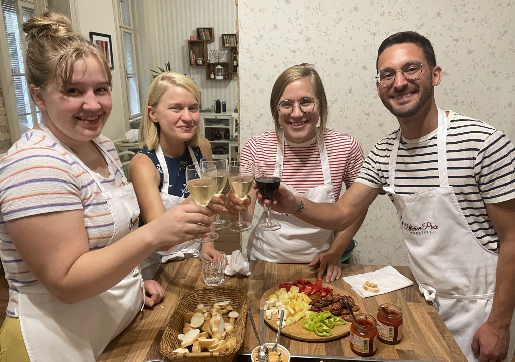 Toasting and tasting at Flavors of Budapest Traditional Hungarian Cooking Class Guests toasting and tasting farmers' plate while Hungarian goulash soup is being prepared during a traditional Hungarian cooking class.